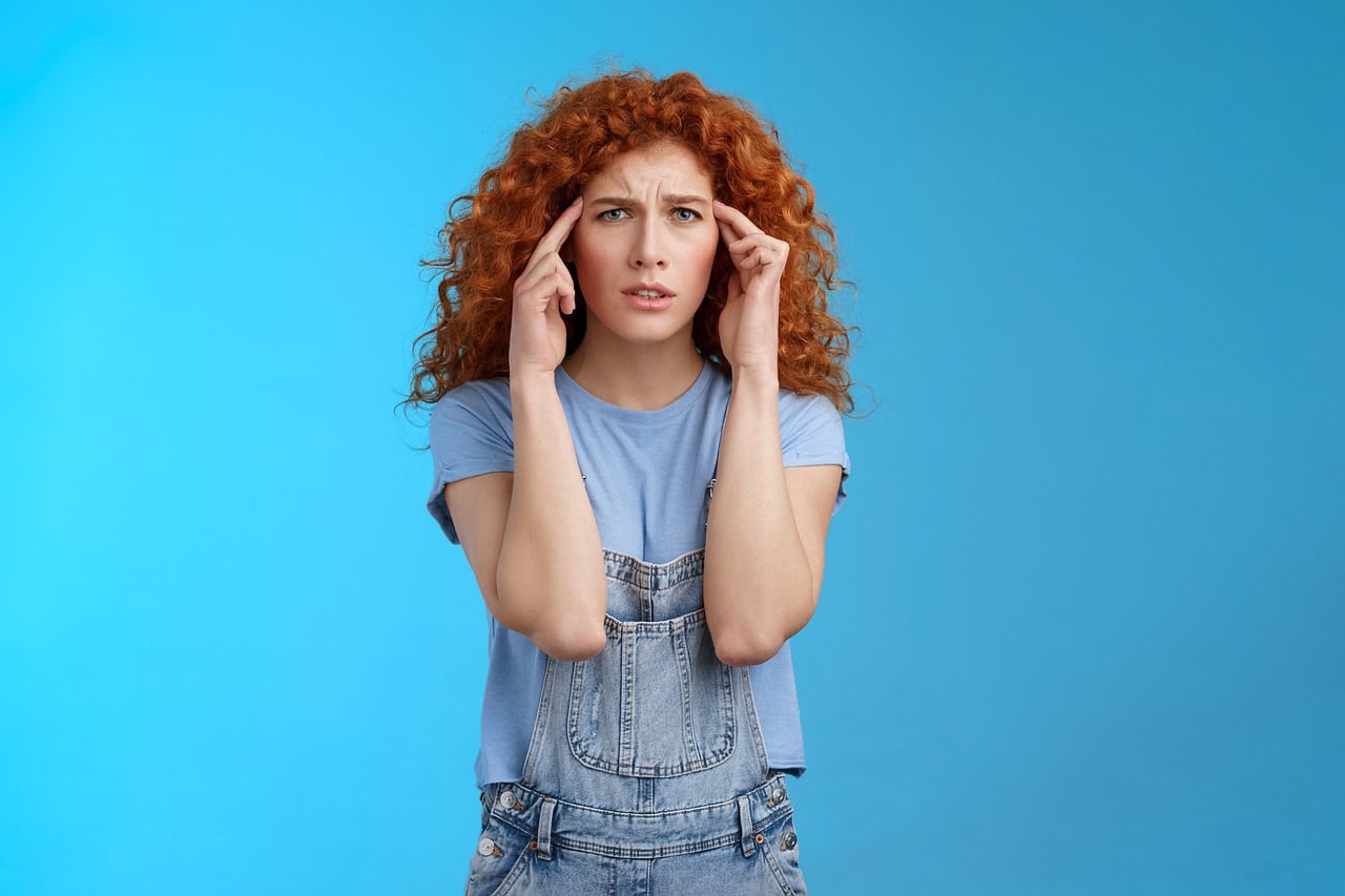 Woman with red heair on a blue background ozempic headache